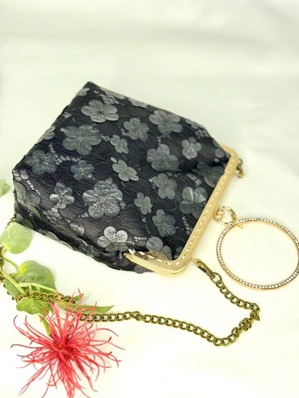 Bolso negro con tejido de flores superpuestas